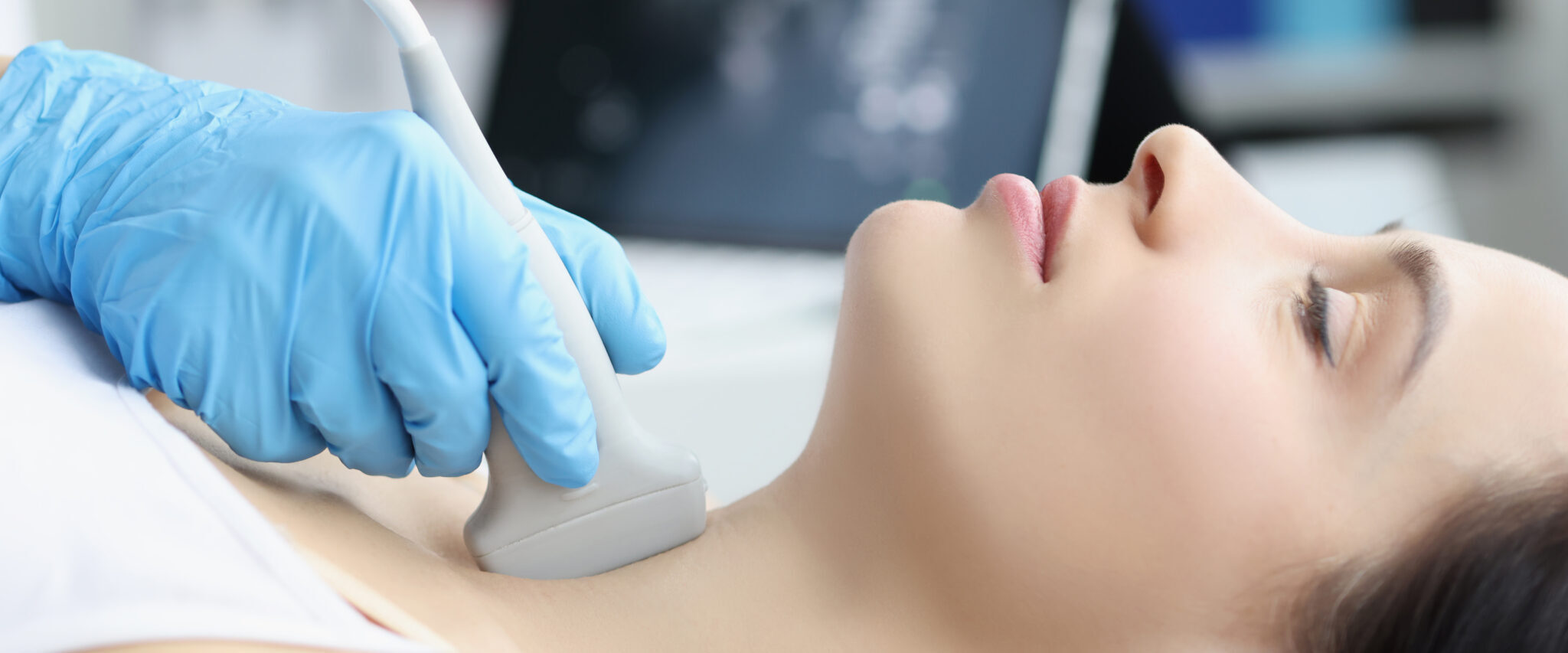 Ultrasound scanning diagnostic of woman thyroid gland in clinic, doctor runs ultrasound sensor