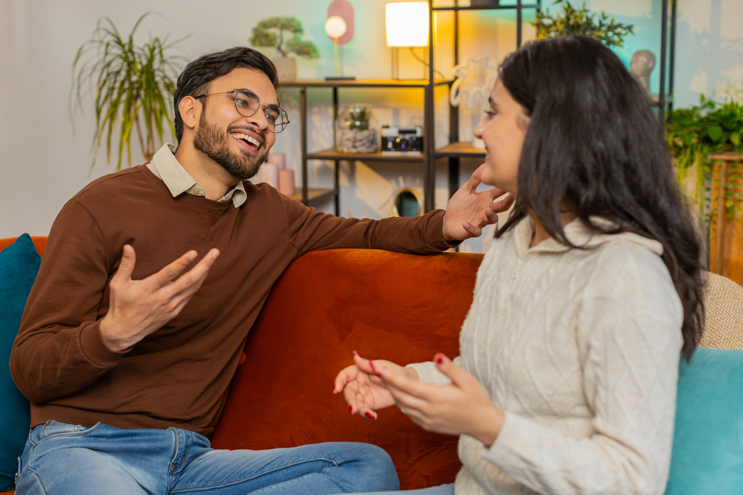 smiling-happy-young-indian-couple-sitting-home-couch-together-having-lovely-conversation-relaxing